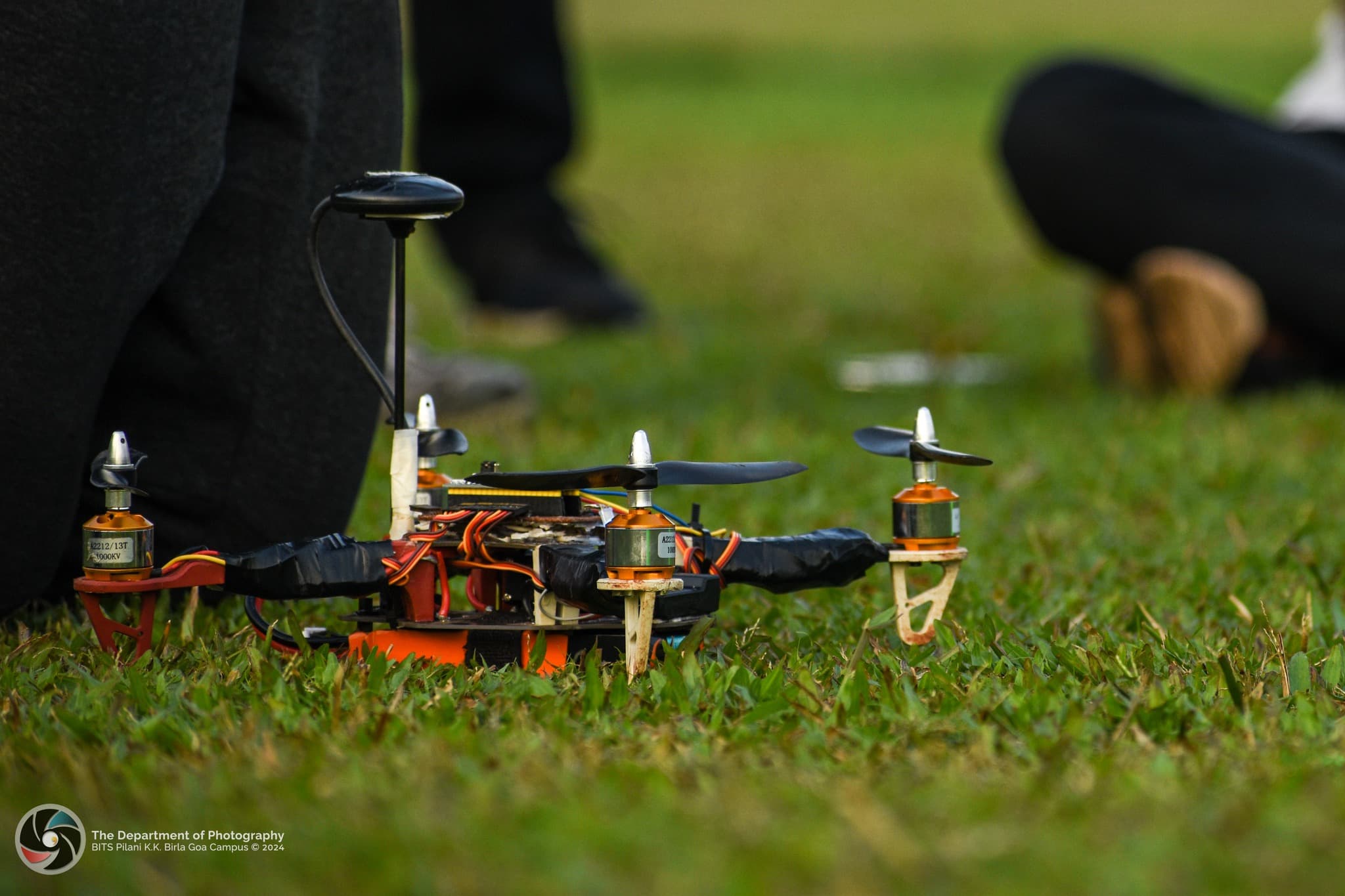 A man wearing a Blue Jays hat looking up at a golden coloured skyscraper in Toronto, Canada with a camera in his hand